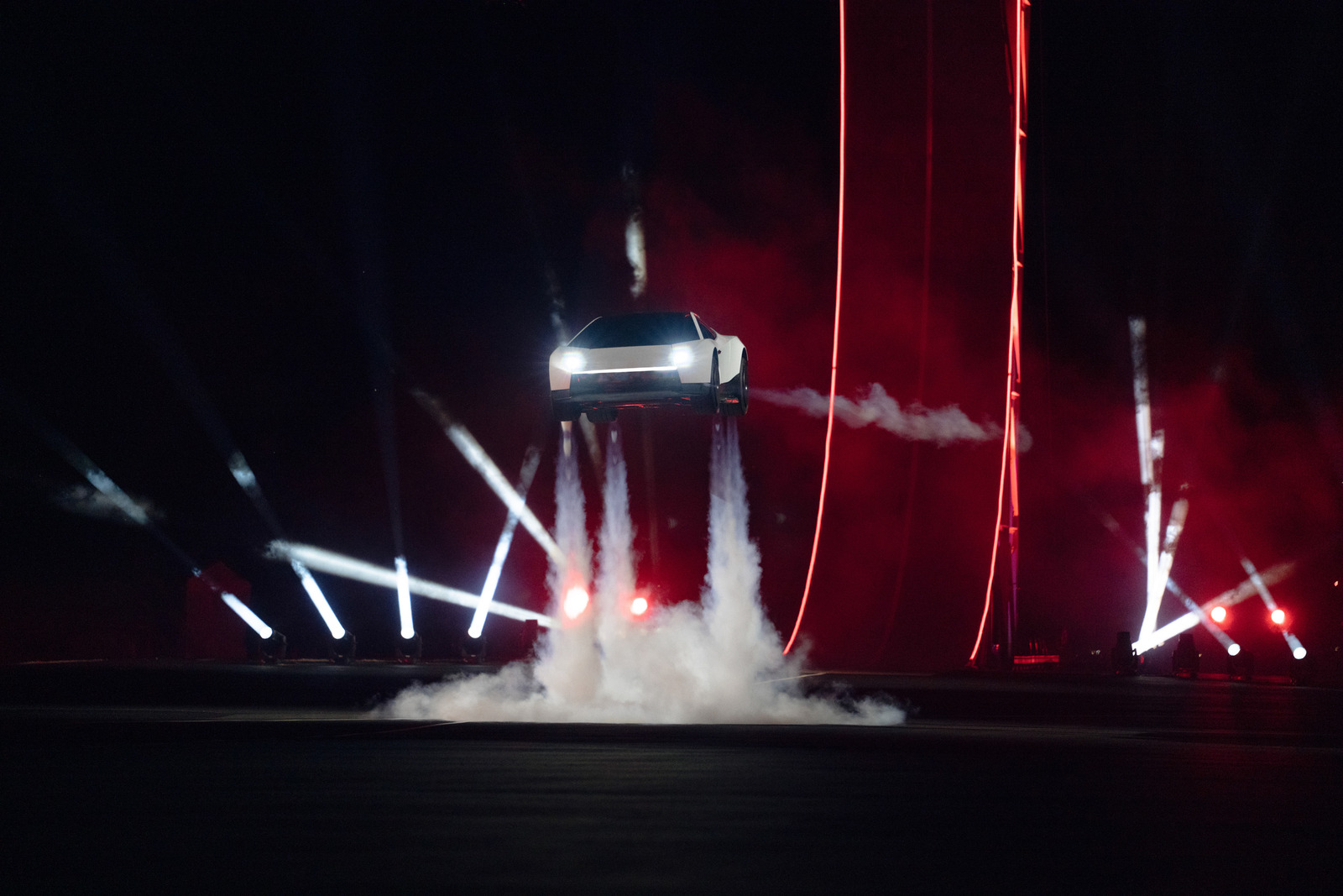 White Tesla Roadster airborne above an illuminated stage at its 2026 unveiling